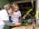 Oudere dame en jongere dame zijn samen bezig met bloemschikken